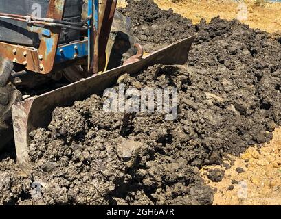 Il trattore Blue sta regolando il terreno. Foto Stock