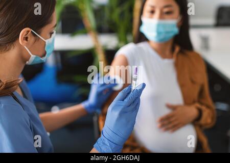 Donna incinta che si prepara a vaccinarsi contro Covid-19 Foto Stock