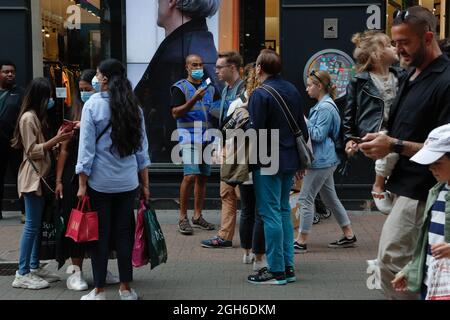 Londra (Regno Unito), 28 agosto 2021: Un operatore di supporto NHS consegna kit di test rapidi covid a membri del pubblico su Carnaby Street a Londra. Foto Stock