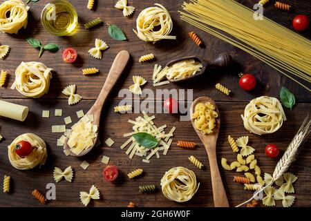 Pasta varia su sfondo di legno Foto Stock