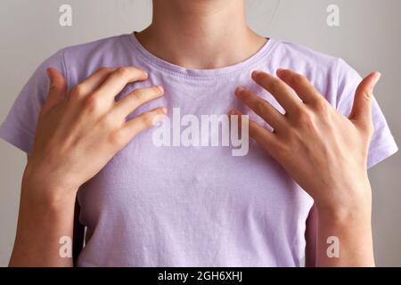 Giovane ragazza adolescente che pratica EFT o la tecnica di libertà emotiva - colpendo sul punto del collarbone Foto Stock