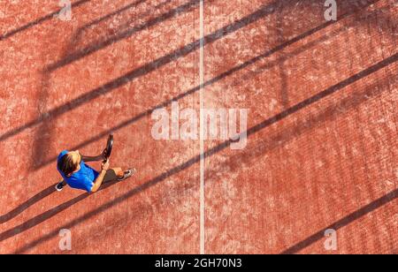 Vista dall'alto di un giocatore professionista di paddle tennis che tiene la racchetta durante una partita su un campo all'aperto. Foto Stock