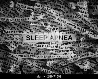 Apnea del sonno. Strappato pezzi di carta con le parole Apnea del sonno. Bianco e nero. Primo piano. Foto Stock