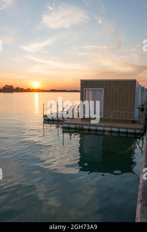 Lignano Sabbiadoro, Italia (3 settembre 2021) - Case galleggianti sulla foce del fiume Tagliamento al tramonto Foto Stock