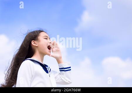 Adolescente studentessa gridando e annunciando qualcosa Foto Stock