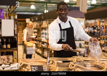 Venditore che offre alimenti alla rinfusa Foto Stock