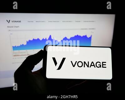 Persona che detiene il telefono cellulare con il logo della società americana di cloud Vonage Holdings Corp. Sullo schermo di fronte alla pagina web. Mettere a fuoco sul display del telefono. Foto Stock
