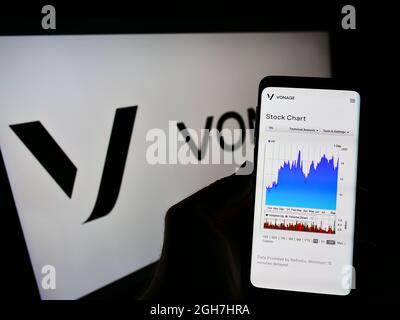 Persona che tiene lo smartphone con il sito web della società cloud statunitense Vonage Holdings Corp. Sullo schermo di fronte al logo. Concentrarsi sul centro del display del telefono. Foto Stock