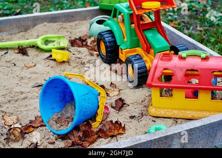 Giocattoli dimenticati nel sandbox esterno. Parco giochi per bambini all'aperto Foto Stock