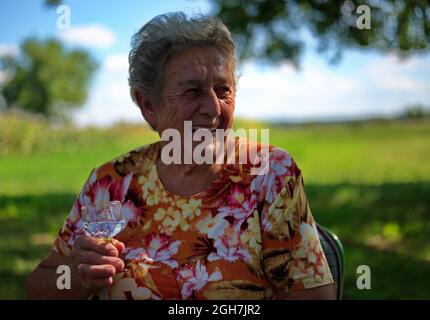 Ritratto di donna anziana seduta in natura Foto Stock