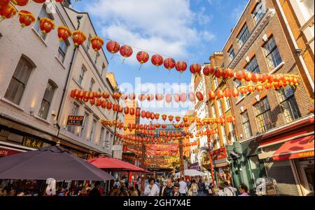 Lanterne cinesi colorate rosse e dorate si stenavano attraverso Gerrard Street a Chinatown nel West End di Londra, nel quartiere City of Westminster W1 Foto Stock