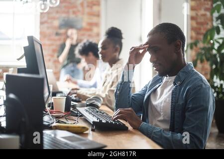 Hacker multietnici maschi e femmine che lavorano in ufficio Foto Stock