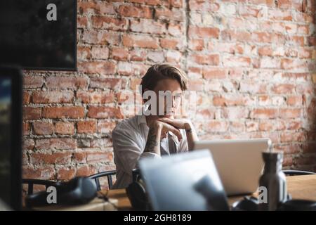 Hacker femminile che lavora su un notebook in un ufficio creativo Foto Stock