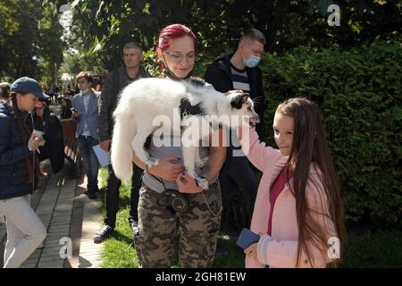 KIEV, UCRAINA - 5 SETTEMBRE 2021 - Una donna tiene una volpe bianca nel Parco di Taras Shevchenko durante il 2021 marzo dei diritti nazionali degli animali, Kiev, capitale di Foto Stock