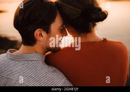 Amici di sesso maschile che trascorrono tempo libero durante il tramonto Foto Stock