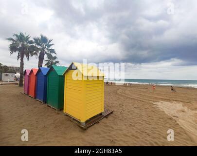 Capanne di legno di vari colori nella sabbia della spiaggia di Oropesa del Mar in una giornata nuvolosa, a Castellón, in Spagna. Europa. Fotografia orizzontale. Foto Stock