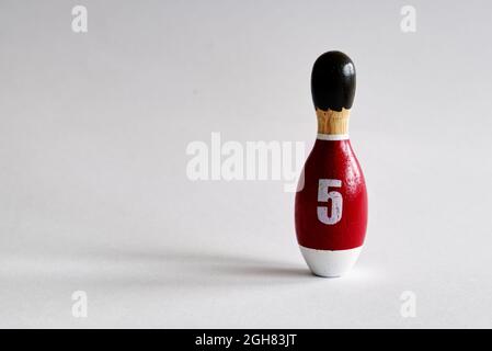 vista posteriore di un burattino di legno a forma di birilli con una camicia numero cinque Foto Stock