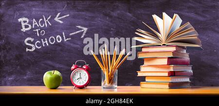 Concetto di ritorno a scuola - tempo per studiare - Apple e matite con Stack Books e sveglia Foto Stock