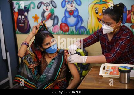 L'operatore medico inocula una donna con il jab del vaccino Covid-19 in un ospedale distrettuale il 22 giugno 2021 a Nuova Delhi, India. Foto Stock