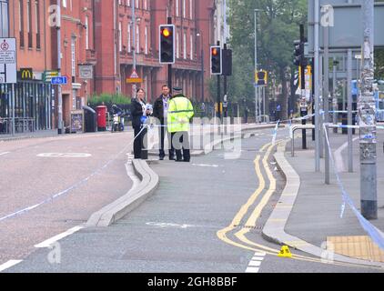 Manchester, Regno Unito, 6 settembre 2021. La polizia ha indonato l'incrocio tra Oxford Road e Devas Street e gli ufficiali legali stanno indagando intorno a una tenda di polizia, con ufficiali in uniforme che sorvegliano la scena. I marcatori di evidenza sono a terra. La polizia di Greater Manchester ha dichiarato: "Questo incidente ha portato un uomo a subire gravi lesioni alla testa". Gli ufficiali di polizia rivestiti in modo semplice parlano con un ufficiale in uniforme. Credit: Terry Waller/Alamy Live News Foto Stock