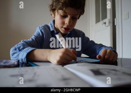 Bambino che frequenta la scuola a casa, impara a scrivere la sceneggiatura corsiva, Parigi, Francia Foto Stock