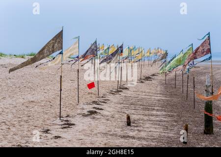 Nairn East Beach, Highlands, Scozia, Regno Unito. 5 Settembre 2021. Come parte del Nairn Books and Arts Festival c'era una Kinetika Flag Installation. ' Una splendida installazione di 500 bandiere di seta colorate naturalmente sulla East Beach di Nairn da parte della compagnia internazionale di arti all'aperto Kinetika. Create da comunità lungo la costa orientale del Regno Unito come parte del progetto Beach of Dreams, le bandiere saranno potenziate da bandiere ispirate da Nairn Beach create da membri della comunità locale in laboratori guidati da Ali Pretty, Direttore artistico di Kinetika. ' CREDIT - JASPERIMAGE/AlamyLiveNews Foto Stock