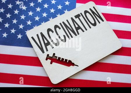 Parola di vaccinazione sul plat e bandiera degli Stati Uniti. Foto Stock