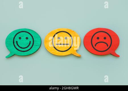 Concetto di indice di soddisfazione del cliente. Facce sorridenti sui piatti. Foto Stock