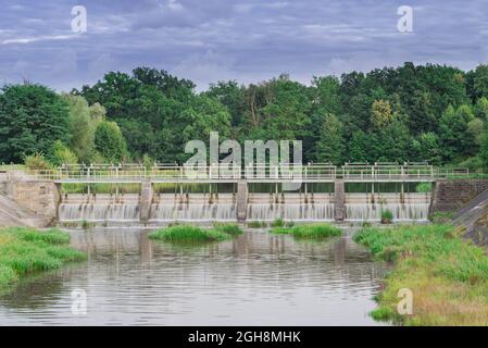 Una diga che regola il livello dell'acqua sul fiume. Foto Stock