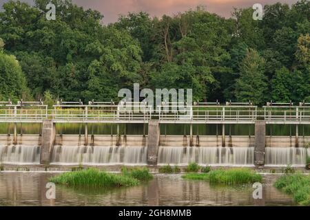 Una diga che regola il livello dell'acqua sul fiume. Foto Stock