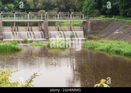 Una diga che regola il livello dell'acqua sul fiume. Foto Stock