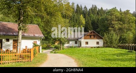 Panorama di un percorso a piedi e case tradizionali nelle montagne di Sumava, Repubblica Ceca Foto Stock