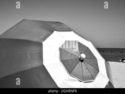 ombrello colorato contro il cielo blu estivo lungo la spiaggia Foto Stock