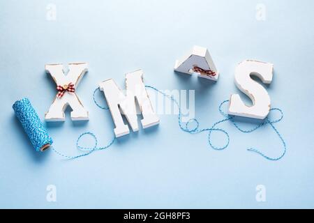 Vecchio volume bianco lettere natale e cordoncino blu, fiocchi di neve su sfondo blu. Banner di Natale. Vista dall'alto. Disposizione piatta. Mock up. Foto Stock