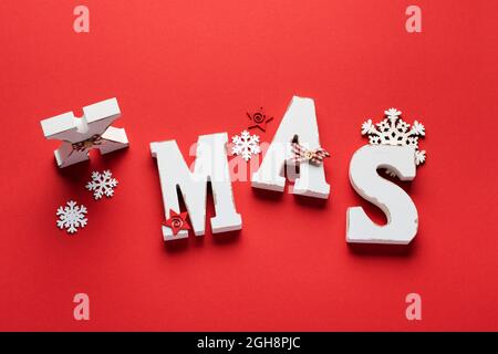 Vecchio volume bianco lettere natale e cordone rosso, fiocchi di neve su sfondo rosso. Banner di Natale. Vista dall'alto. Disposizione piatta. Mock up. Foto Stock