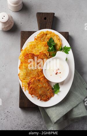 Draniki - potatof ritters, pancake vegetariani di patate, serviti con erbe fresche e salsa allo yogurt all'aglio, vista dall'alto Foto Stock