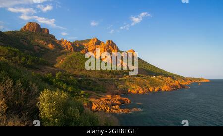 Scogliere vulcaniche rosse e arancioni e colline tra Agay e Cannes nel massiccio dell'Esterel. Foto Stock