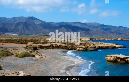 Vista sulla solitaria spiaggia di la Galera, ad Aguilas, nella Costa Calida, regione di Murcia, Spagna, con la catena montuosa di Calnegre nel backgrou Foto Stock