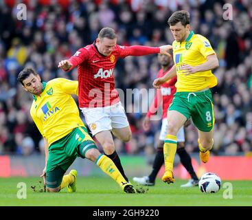 Bradley Johnson di Norwich City (l) affronta Wayne Rooney di Manchester United come Jonathan Howson di Norwich City (r) chiude durante la partita della Barclays Premier League tra Manchester United e Norwich City al Old Trafford il 02 marzo 2013. Foto Simon Bellis Foto Stock