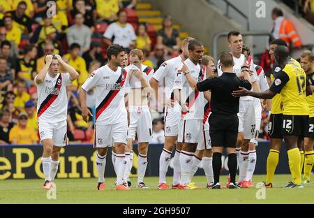 I giocatori di Bournemouth si lamentano dell'arbitro James Adcock dopo che una decisione li va contro durante la partita del campionato di Sky Bet fra Watford e AFC Bournemouth tenuta a Vicarage Road in Watford, Regno Unito il 10 agosto 2013. Foto di: David Klein Foto Stock