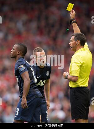 L'arbitro Andre Marriner mostra una carta gialla a Tom Cleverley del Manchester United durante la partita della Barclays Premier League tra Liverpool e Manchester United all'Anfield di Liverpool il 1° settembre 2013. . Foto Stock