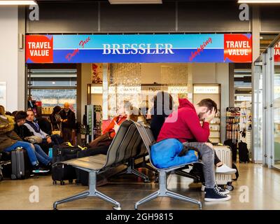 Persone stanche passeggeri in attesa nel terminal del piccolo aeroporto di Baden con Bressler shopping duty free store Foto Stock