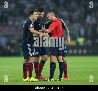 Russell Martin, Grant Hanley e Alan Hutton in Scozia mettono in discussione la quantità di tempo aggiunto dall'arbitro Svein Oddvar Moen durante la partita di qualificazione UEFA euro 2016, gruppo D tra Germania e Scozia al Signal Iduna Park di Dortmund il 7 settembre 2014. Foto Stock