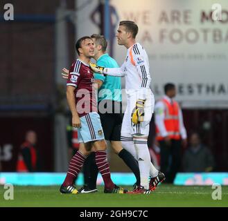 Mark Noble di West Ham esorta Adrian a calmarsi durante la partita della Barclays Premier League tra West Ham United e Liverpool tenutasi all'Upton Park di Londra, Inghilterra, il 20 settembre 2014. Foto Stock