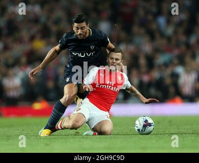 L'Arsenal's Jack Wilshere si inonda con il Dusan Tadic di Southampton durante la partita Capital One Cup Third Round all'Emirates Stadium di Londra il 2014 settembre. Foto Stock