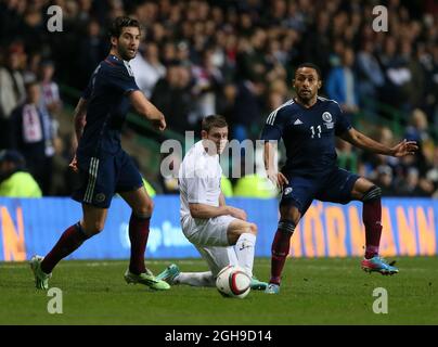 Ikechi Anya della Scozia si inchinano con James Milner dell'Inghilterra durante la partita internazionale amichevole tra Scozia e Inghilterra tenutasi al Celtic Park di Glasgow, Scozia, il 18 novembre 2014. Foto Stock