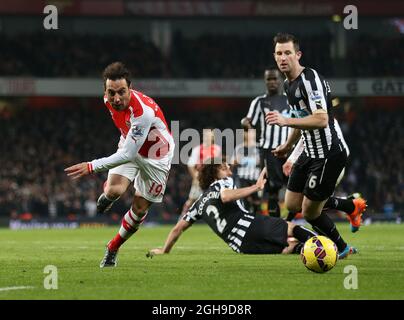 I Santi Cazorla dell'Arsenal si scontrano con Mike Williamson di Newcastle durante la partita della Barclays Premier League tra l'Arsenal e Newcastle United all'Emirates Stadium di Londra, in Gran Bretagna, il 13 dicembre 2014. Foto Stock