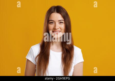 Bella giovane donna in posa su sfondo colorato studio Foto Stock
