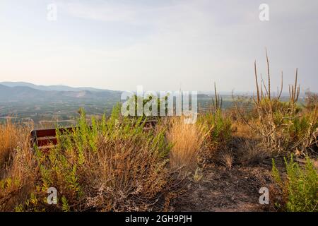 Panchina abbandonata del parco con una bella vista in lontananza (Lost Place) Foto Stock