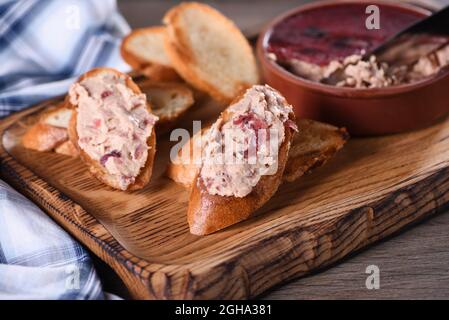 Delicato pato di pollo con purè di mirtilli spalmato su fette di baguette tostate. Cibo di stile country. Foto Stock